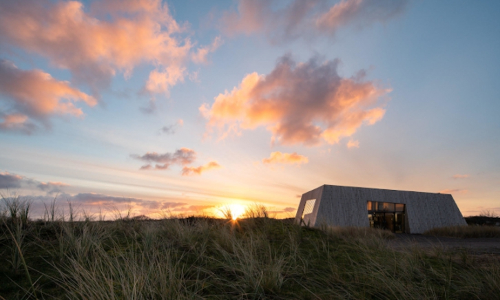 Fortuna Vlieland brouwerij tussen de duinen met een ondergaande zon